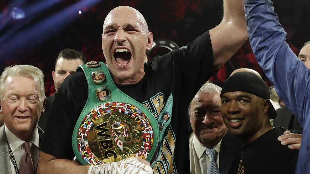 Tyson Fury slaví s pásy a svými nejbliími triumf nad Deontayem Wilderem.