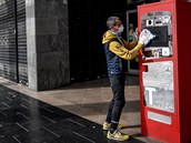 Mu dezinfikuje automat na cigarety v italském Casalpusterlengu.