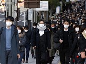 Lidé s ochrannými roukami v Tokiu.