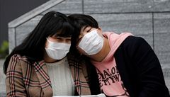 Japonci s roukami ped nákupním centrem v Tokiu.