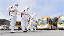 Pracovníci dezinfikují autobusy ve městě Gwangju v Jižní Koreji.