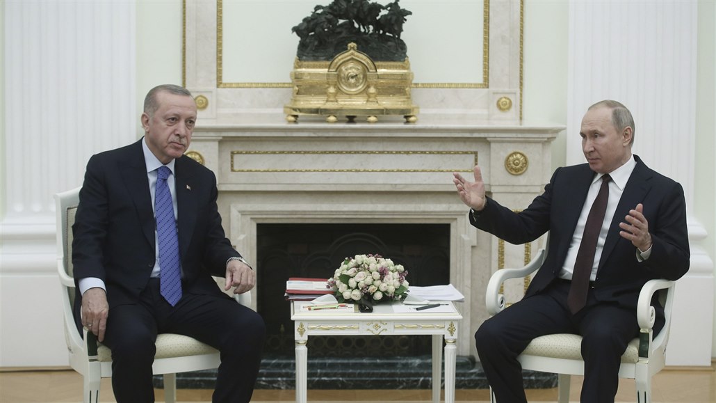 Vladimir Putin hovoí s Recepem Erdoganem. Socha nad krbem zachycuje ruská...