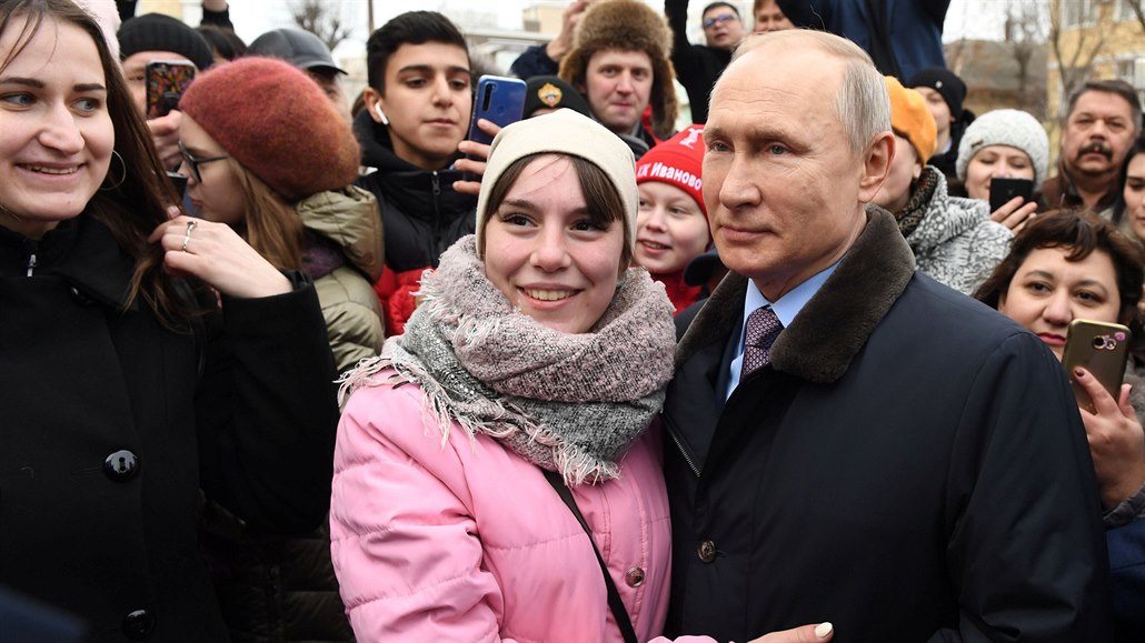 Prezident Vladimir Putin se nechává vyfotit s jednou z místních obyvatelek ve...