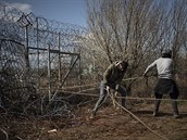 Migranti se snaí zniit ostnatý plot na ecké hranici s Tureckem a pejít do...