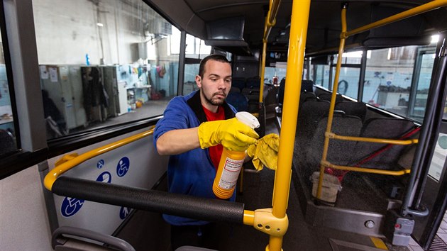Pracovník úklidové firmy dezinfikuje interiér autobusu dopravce FTL v...