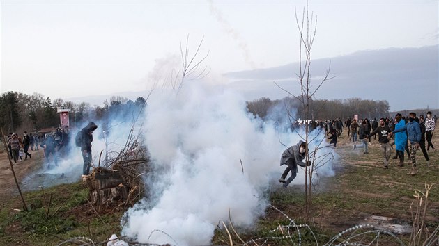 Migrant hází dopadnutý granát se slzným plynem zpt na policisty na ecké...