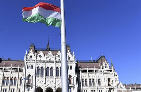 Vztažená maďarská vlajka před parlamentem v Budapešti.