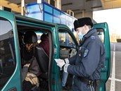Maarský policista kontroluje doklady ukrajinskému dlníkovi, který chce...