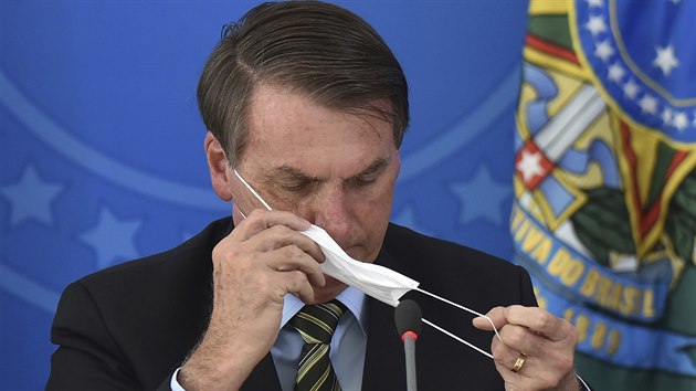 Brazilský prezident Jair Bolsonaro si navléká rouku.