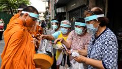 Buddhisti�tí mni�i vybírají almu�nu v thajském Bangkoku.