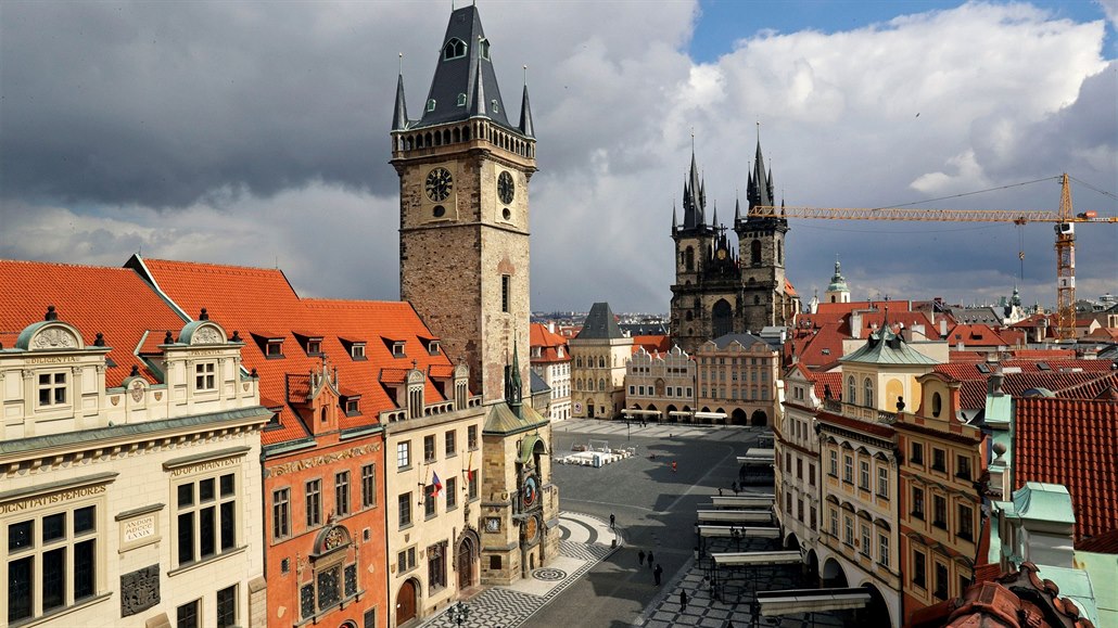 Hodiny na Staromstské radnici odbíjejí pravé poledne, turisté se do centra...