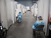 Zdravotníci kontrolují pacienty s nemocí covid-19 v kongresovém centru Javits,...