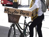 ena s nápisem modleme se za Borise na jejím kole v ulicích Londýna.