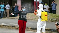 Indonéský zdravotník dezinfikuje migrantku, která p�i�la za prací z Malajsie.