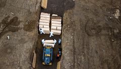 Pracovníci v ochranných od�vech poh�bívají mrtvoly na ostrov� Hart v New Yorku,...