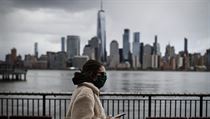 Panorama města New York City se táhne nad chodci, kteří nosí masky kvůli obavám...