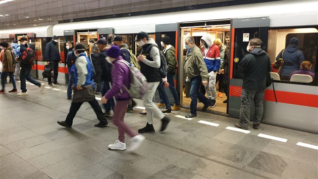 Lidé v roukách vystupují z vagonu metra.