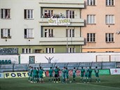 Fotbalisté Bohemians dkují fanoukm na balkon bytovek u stadionu.