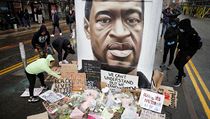 Protestujc v Manchesteru kladou kvtiny a transparenty k podobizn zesnulho...