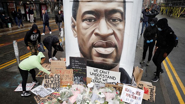 Protestující v Manchesteru kladou kvtiny a transparenty k podobizn zesnulého...