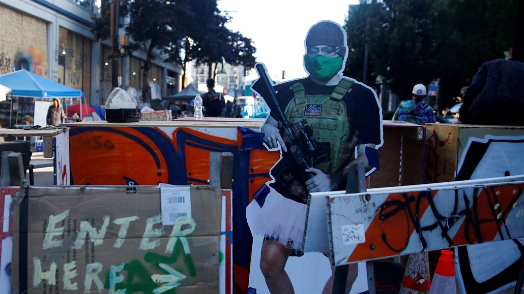 Namalovaná postavička se zbraní, která „chrání“ autonomní zónu v Seattlu na...