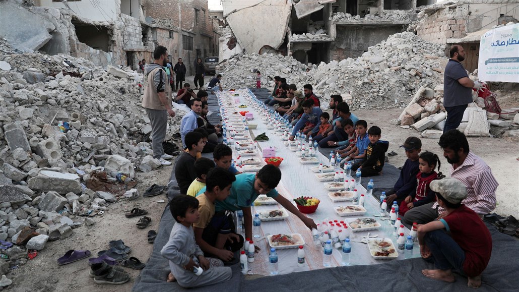 Syané ekají na modlitbu ped jídlem, které jim poskytli dobrovolnické skupiny.