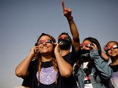 Mladiství pozorují slunce s ochrannými brýlemi. jíní Israel,21.erven, 2020.