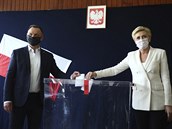 Souasný polský prezident Andrzej Duda s manelkou vhazují své volební lístky.
