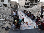 Syané ekají na modlitbu ped jídlem, které jim poskytli dobrovolnické skupiny.