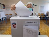 Voli s roukou na oblieji vhazuje svj hlas do urny bhem chorvatským voleb.