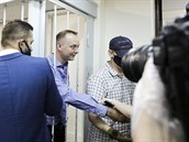Ivan Safronov si podává ruku se svými pívrenci v soudní síni.