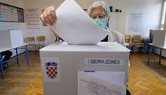 Voli s roukou na oblieji vhazuje svj hlas do urny bhem chorvatským voleb.