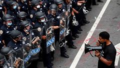 Jeden z demonstrujících stojí proti zástup policist v New Yorku.