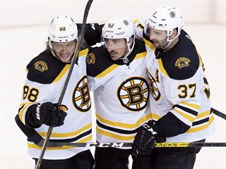 Radujc se hokejist Bostonu Bruins. Uprosted Brad Marchand, vlevo David...