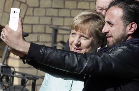 Neznámý muž se fotí s německou kancléřkou Angelou Merkelovou při její návštěvě...