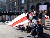 Opoziní podporovatelé s bílo-ervenými vlajkami.