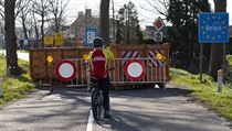 Cyklista si fot zabarikdovanou hranici mezi Nizozemskem a Belgi.