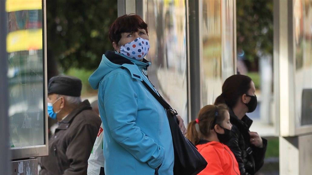 Lidé na zastávce autobusu v době koronavirové pandemie. Ilustrační snímek