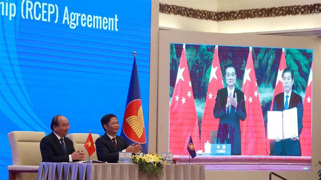 Podpis dohody. Vietnamský premiér a ministr obchodu vedle obrazovky, na které...