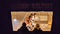 Výdejní okénko kultury, za kterým stojí soubor Cirk La Putyka.