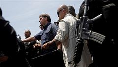 Brazilský prezident Jair Bolsonaro s ochrankou opoutí volební místnost. V...