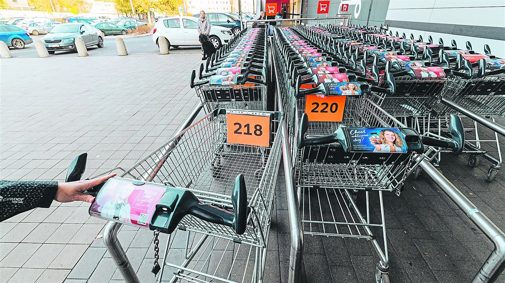Očíslované vozíky před supermarketem.