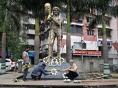 Lidé v Indii zdobí Maradonovu sochu.