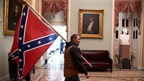 Podporovatel Donalda Trumpa uvnit budovy Kapitolu tmajc konfederan...