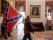 Podporovatel Donalda Trumpa uvnit budovy Kapitolu tímající konfederaní...