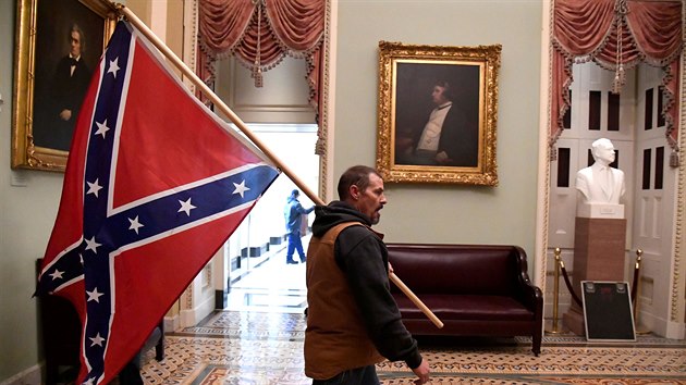 Podporovatel Donalda Trumpa uvnit budovy Kapitolu tímající konfederaní...