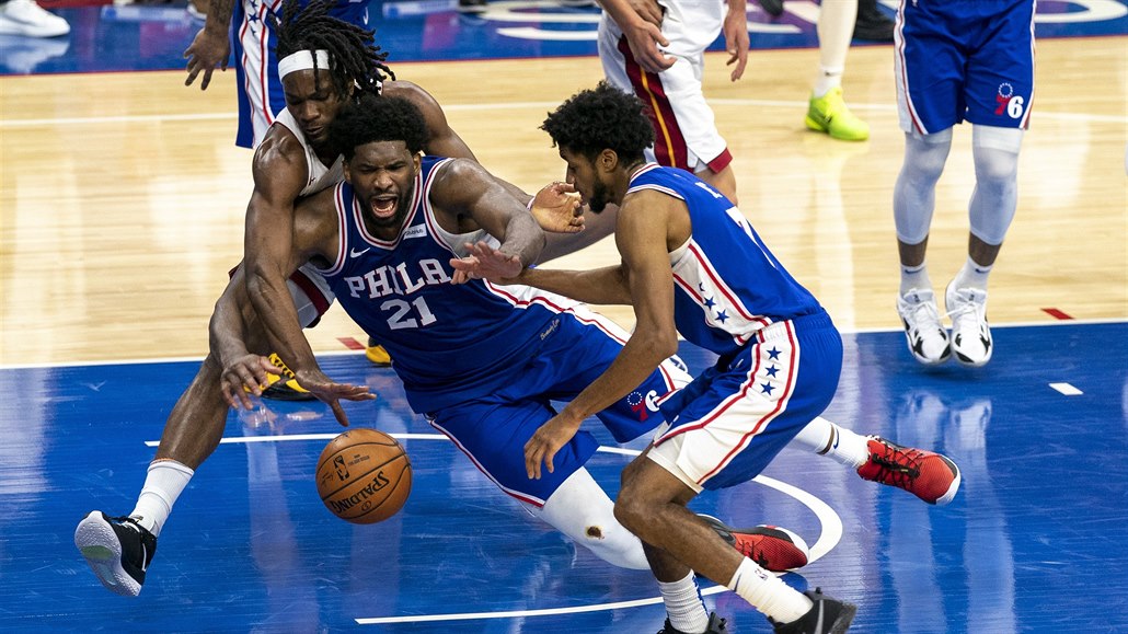 Basketbalista  Philadelphie Joel Embiid (uprostřed) se snaží ubránit míč proti...