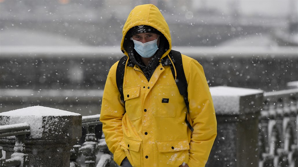 Muž 12. ledna 2021 za hustého sněžení prochází centrem Prahy.