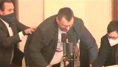 Neza�azen� poslanec Lubom�r Voln� (uprost�ed) se p�etahuje o mikrofon s poslanci Ond�ejem Vesel�m (vlevo) a Janem Chvojkou p�i jedn�n� Poslaneck� sn�movny 21. ledna 2021 v Praze. K poty�ce do�lo pot�, co p�edsedaj�c� Tom� Hanzel vypnul Voln�mu mikrofon.
