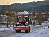 Traktor projídí po trkem posypané silnici u Záhvozdí na Prachaticku.